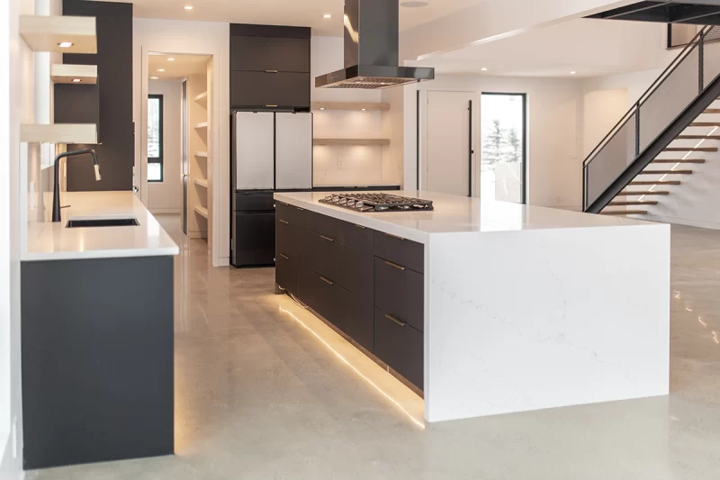 Modern kitchen with charcoal frameless cabinets and a marble waterfall island