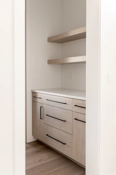 Walk-through pantry with a coffee station in natural wood cabinets