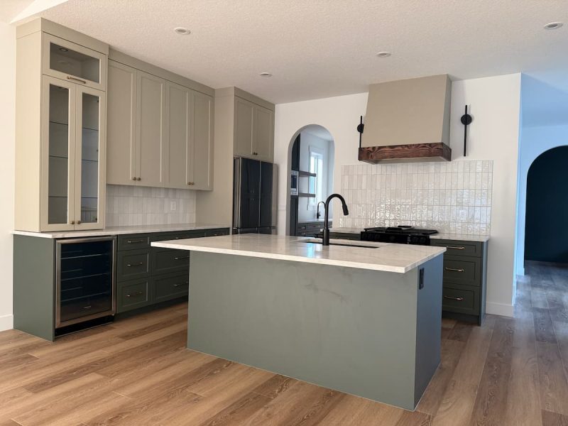 Glass-front tower cabinets in a two-tone Sherwood Park kitchen