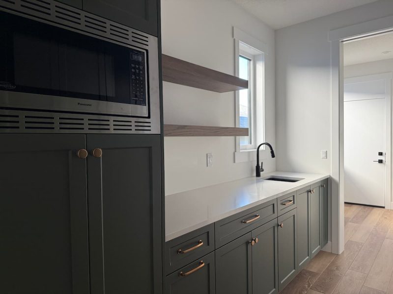 Green butler's pantry with a prep sink, open shelves and a built-in microwave